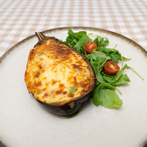 Berenjena rellena al horno con carne picada bechamel, rúcula y tomates cherry Miss Croquette.